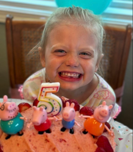 Ella in front of her birthday cake
